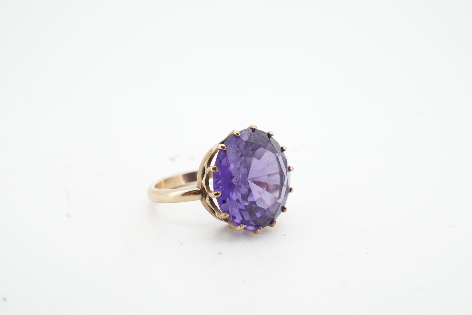 A synthetic colour-change sapphire ring, claw-set with a circular-cut synthetic colour-change sapphire measuring approximately 15 x 15 x 7.9mm, mounted in gold, size H1/2